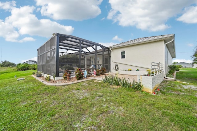 rear view of house featuring glass enclosure and a yard