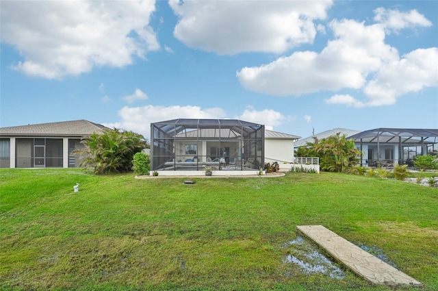 rear view of property with a lanai and a yard