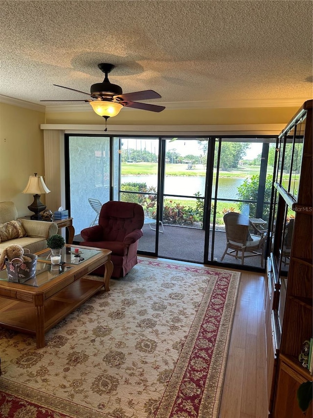 3500 El Conquistador Pkwy Unit 331, Bradenton, FL 34210 - living room featuring a textured ceiling, a water view, hardwood / wood-style floors, crown molding, and ceiling fan