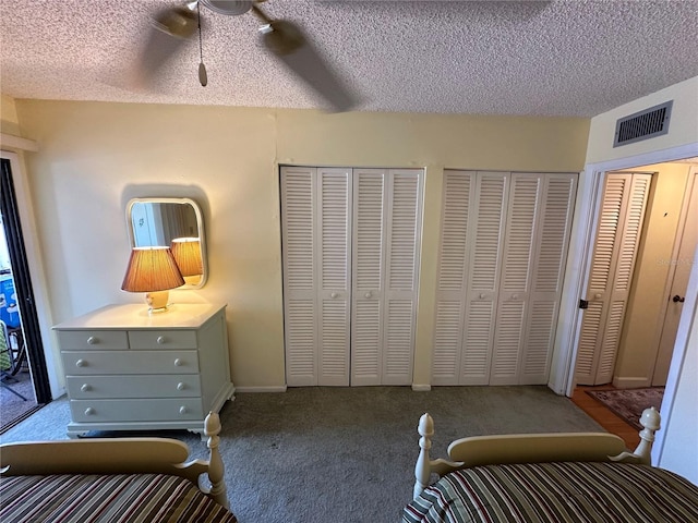 unfurnished bedroom featuring multiple closets, ceiling fan, and a textured ceiling