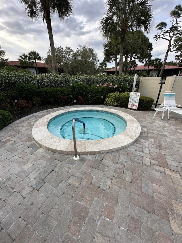 view of swimming pool featuring a hot tub