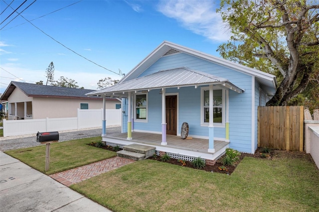 bungalow featuring covered porch and a front lawn