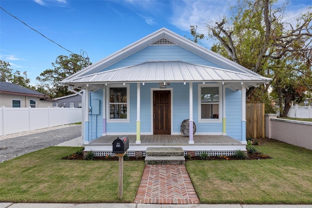 view of front of home with covered porch and a front lawn