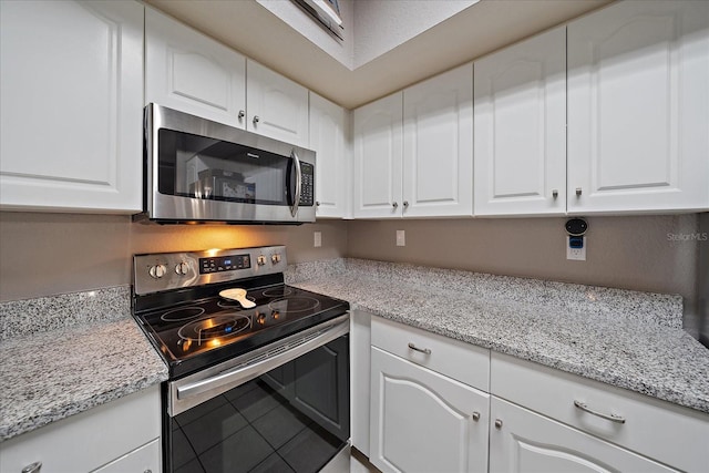 kitchen featuring light stone countertops, white cabinets, and stainless steel appliances