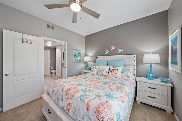 bedroom featuring light carpet, ceiling fan, and connected bathroom