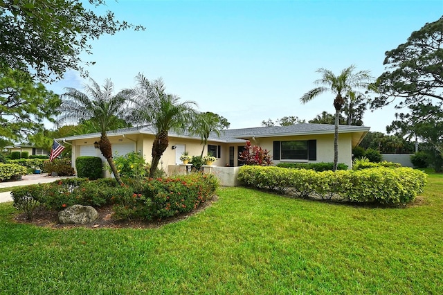 single story home featuring a garage and a front yard