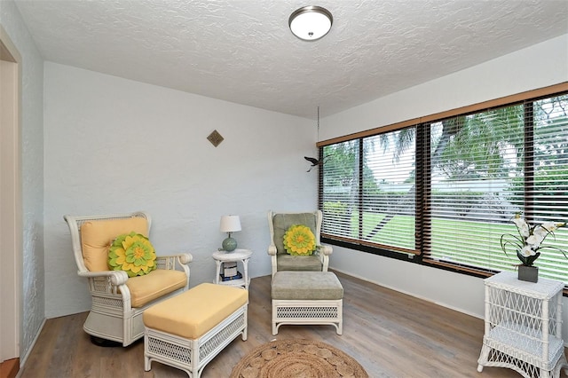 sitting room with wood-type flooring and a textured ceiling