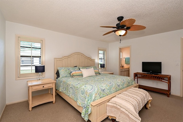 carpeted bedroom with ensuite bathroom, ceiling fan, and a textured ceiling