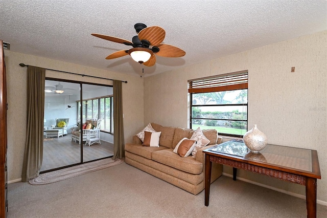 carpeted living room with a textured ceiling and ceiling fan