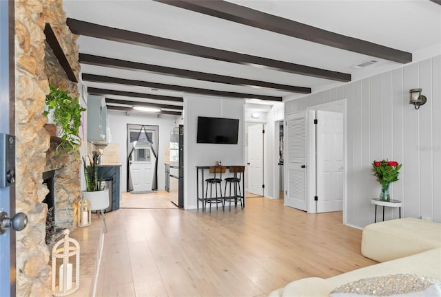 living room featuring light hardwood / wood-style flooring and beam ceiling