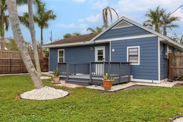 back of property with a yard and a wooden deck