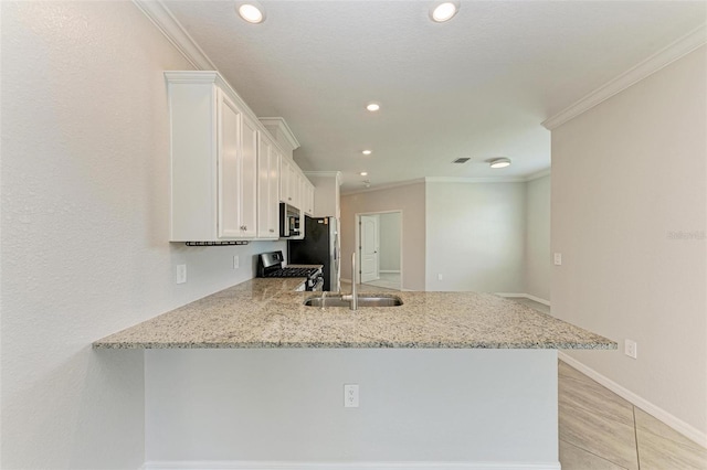 kitchen featuring kitchen peninsula, appliances with stainless steel finishes, ornamental molding, and white cabinets