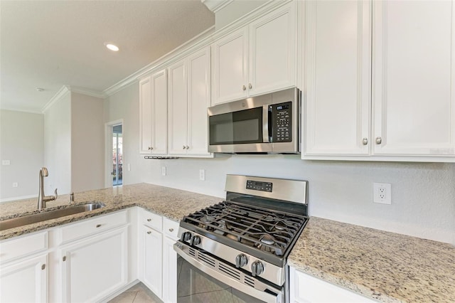 kitchen featuring stainless steel appliances, sink, light stone counters, ornamental molding, and white cabinets