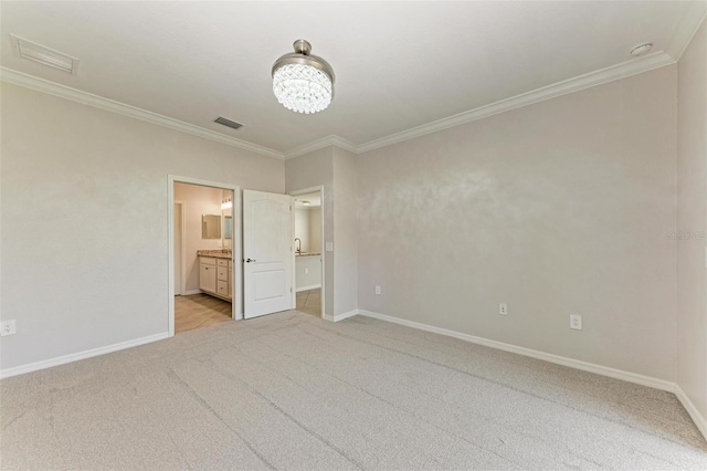 unfurnished bedroom featuring light colored carpet, ensuite bath, an inviting chandelier, and crown molding