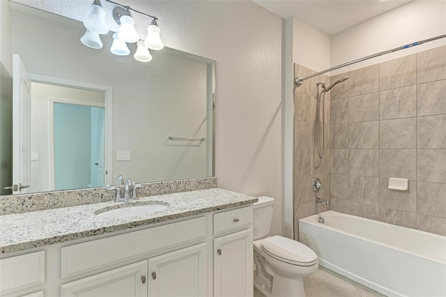 full bathroom with vanity, tiled shower / bath, toilet, and a textured ceiling