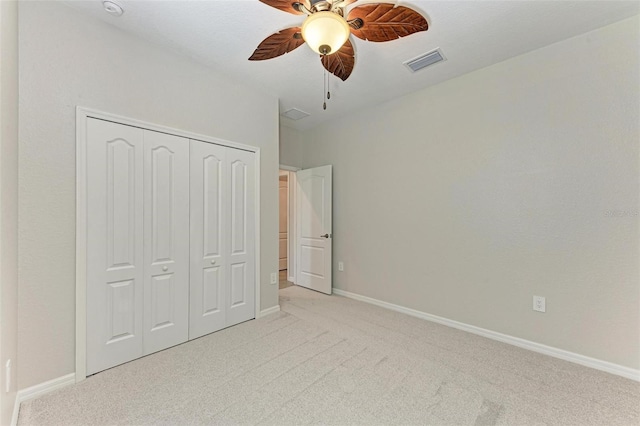 unfurnished bedroom featuring ceiling fan, a closet, and light colored carpet