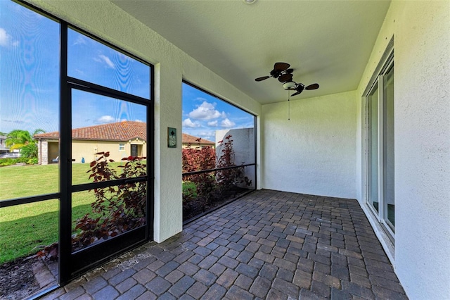 unfurnished sunroom featuring ceiling fan