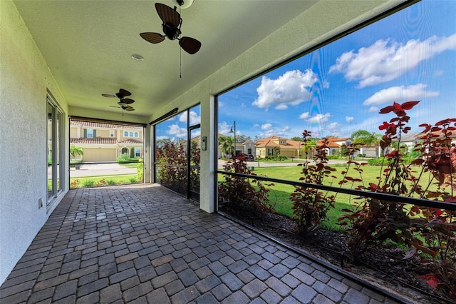 unfurnished sunroom with ceiling fan