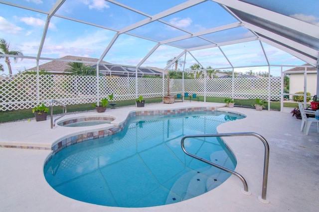 view of pool with glass enclosure, a patio, and an in ground hot tub