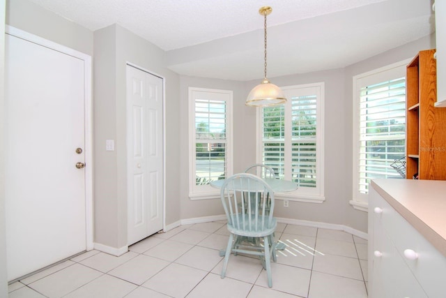 unfurnished dining area with a textured ceiling and light tile patterned floors