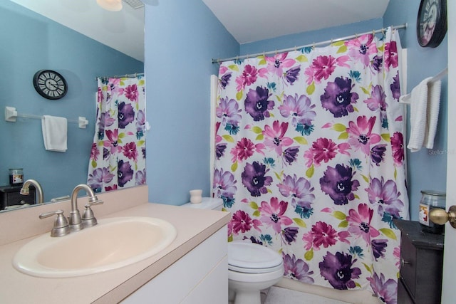 bathroom featuring curtained shower, vanity, and toilet