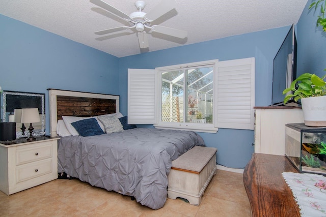 tiled bedroom with ceiling fan and a textured ceiling