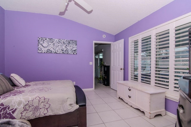 tiled bedroom featuring a textured ceiling, lofted ceiling, and ceiling fan