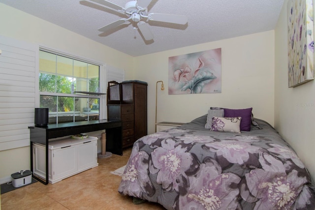 tiled bedroom with a textured ceiling and ceiling fan