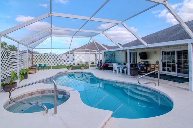 view of swimming pool featuring a lanai, an in ground hot tub, and a patio area