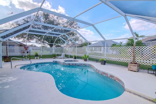 view of swimming pool with glass enclosure, a patio area, and an in ground hot tub