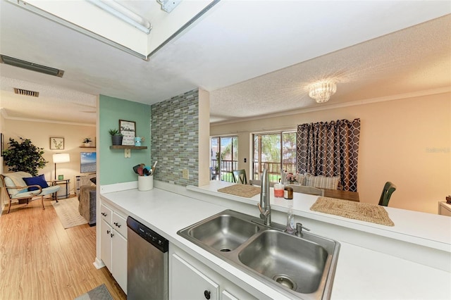 kitchen with light wood-type flooring, stainless steel dishwasher, a textured ceiling, sink, and white cabinets