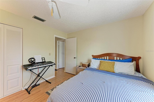 bedroom with a closet, light hardwood / wood-style flooring, and a textured ceiling