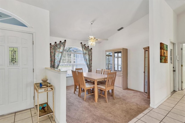 dining room featuring ceiling fan, light colored carpet, and vaulted ceiling