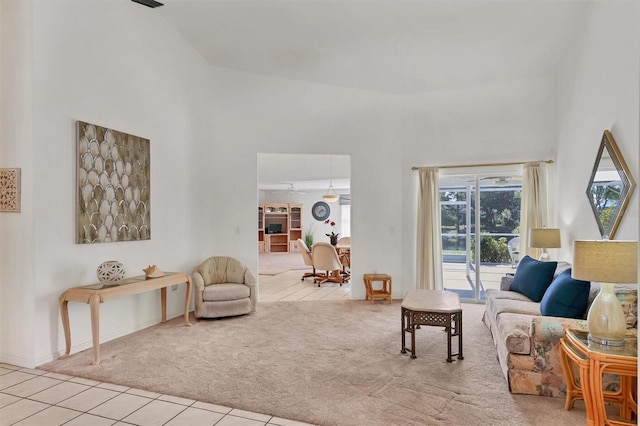 living room with light carpet, a towering ceiling, and ceiling fan