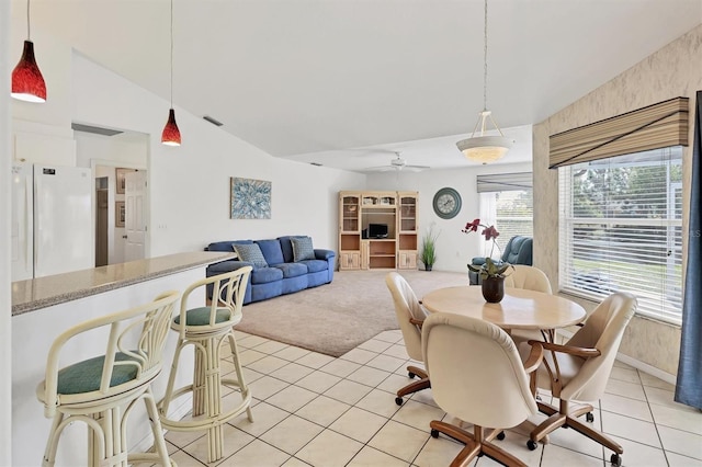 carpeted dining room with ceiling fan and lofted ceiling