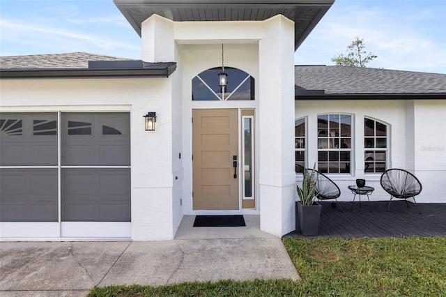 1953 Wheeling Ave, North Port, FL 34288 - entrance to property featuring a shingled roof, an attached garage, stucco siding, and driveway
