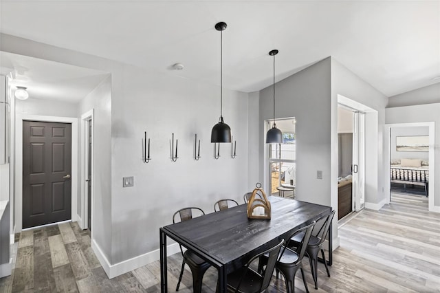 dining area featuring hardwood / wood-style floors and lofted ceiling