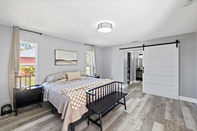 bedroom featuring wood-type flooring, a barn door, and radiator heating unit