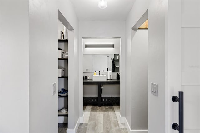 hallway featuring light wood-type flooring and sink