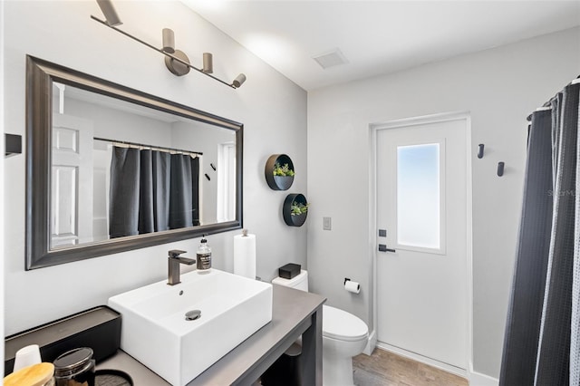 bathroom featuring sink, a shower with shower curtain, and toilet