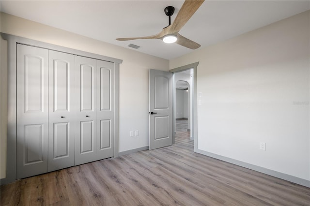 unfurnished bedroom with ceiling fan, a closet, and light hardwood / wood-style flooring