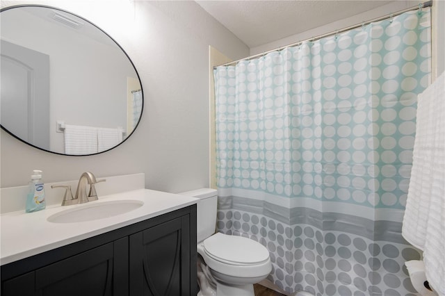 bathroom featuring vanity, a textured ceiling, and toilet