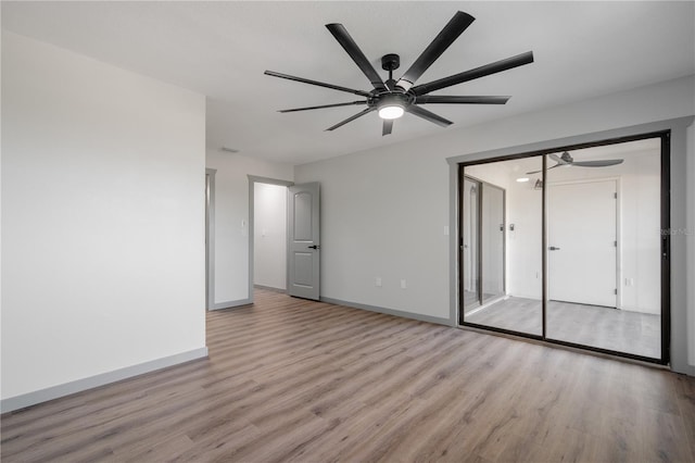 unfurnished bedroom featuring ceiling fan, a closet, and light hardwood / wood-style flooring