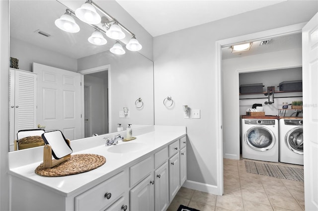 bathroom with tile patterned floors, vanity, and washing machine and dryer