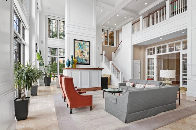 living room featuring beamed ceiling, a towering ceiling, ornamental molding, and coffered ceiling