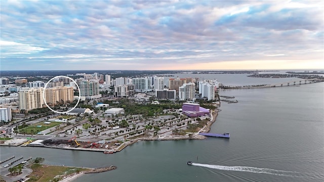 aerial view at dusk featuring a water view