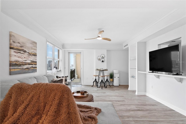 living room featuring light hardwood / wood-style flooring, ceiling fan, and crown molding