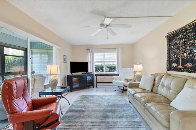 living room featuring ceiling fan, light tile patterned flooring, and a textured ceiling