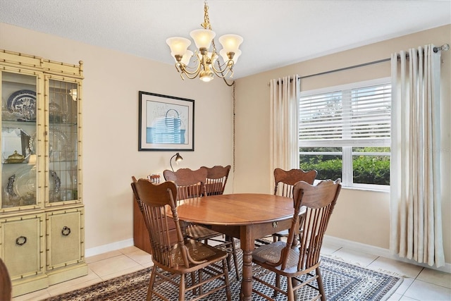 tiled dining space with a chandelier and a textured ceiling