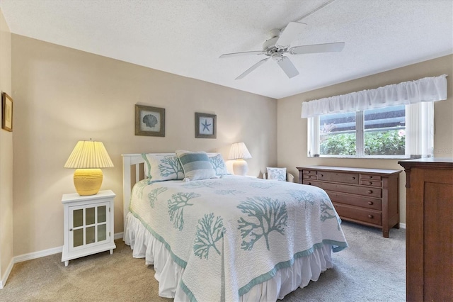 bedroom featuring ceiling fan, light carpet, and a textured ceiling